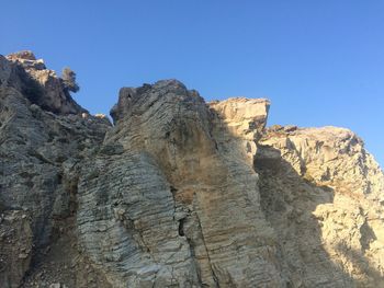 Low angle view of rocks against clear sky