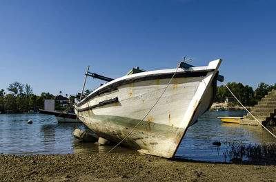 Boats moored on sea against clear sky