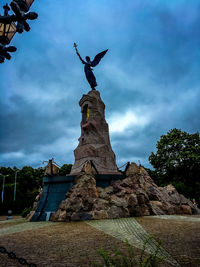 Low angle view of statue against cloudy sky