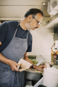 Mature chef working in kitchen of food truck