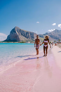 People on beach against sky