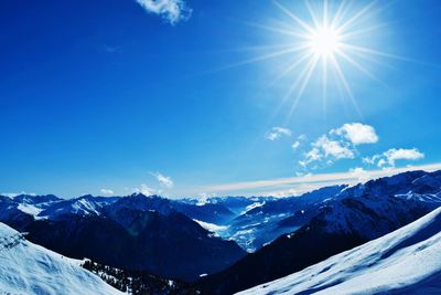 Sun shining over snowcapped mountains