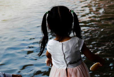 Rear view of woman standing in water