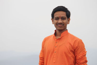 Portrait of young man standing against sky