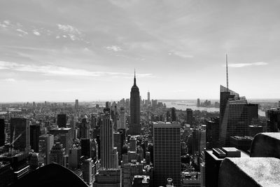 Aerial view of buildings in city against cloudy sky