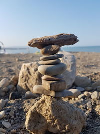 Stack of pebbles on beach against clear sky