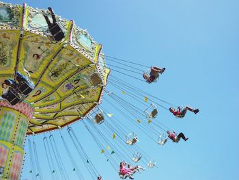 Low angle view of people enjoying chain swing ride