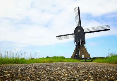 Traditional windmill on field against sky