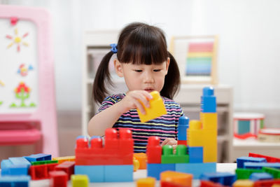 Girl playing with blocks at home