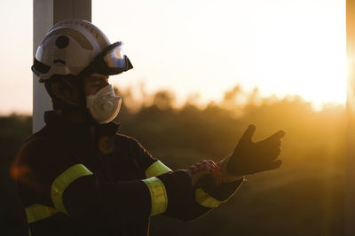 Firefighter getting dressed to start work disinfecting a building