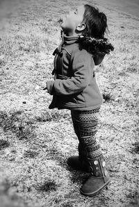 Woman with umbrella standing on shore