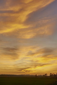 Scenic view of field against orange sky