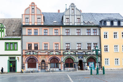 Residential building by street against sky