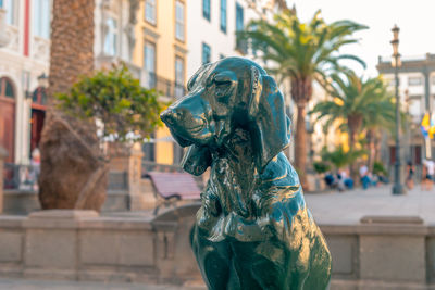 Close-up of statue against buildings in city