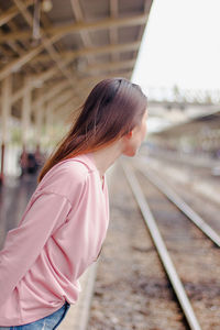 Woman standing at railroad station platform
