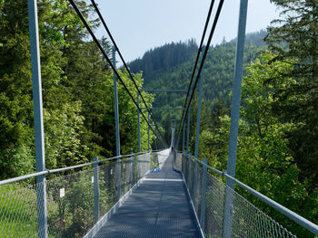 Low angle view of footbridge against trees