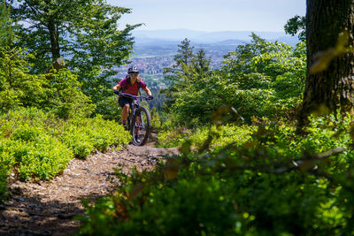 A young woman riding a mountain bike on a singletrail in the austrian alps near klagenfurt, austria.