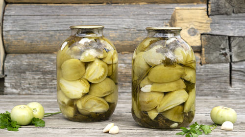 Homemade pickled green tomatoes in a glass jars with garlic and parsley. home preservation.
