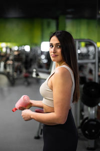 Portrait of young woman exercising at gym