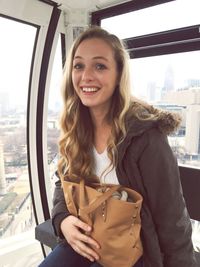 Portrait of happy young woman traveling in overhead cable car