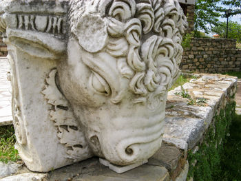 Close-up of statue against stone wall