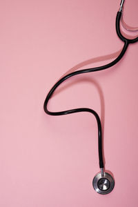 Close-up of electric lamp against pink background