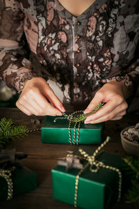 Woman making beautiful christmas gift at table