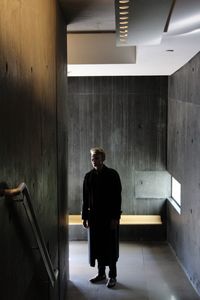 Rear view of man walking in corridor of building