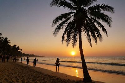 Silhouette people on beach during sunset