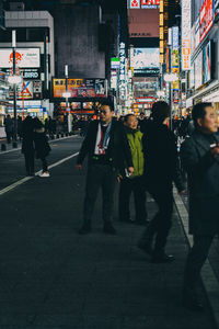 People walking on footpath in city