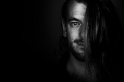 Portrait of young man against black background