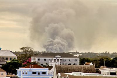 Smoke emitting from burning building against sky