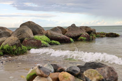 Rocks on beach against sky