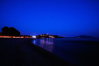 Scenic view of sea against clear blue sky at night