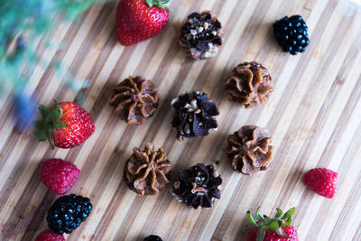 High angle view of berry fruits and dessert on table