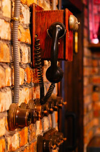 Close-up of old machine part on brick wall