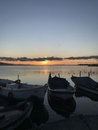 Boats moored in marina at sunset