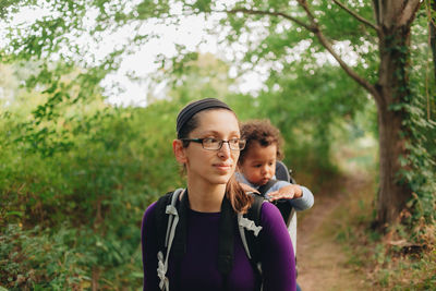 Portrait of mother and daughter against trees and plants