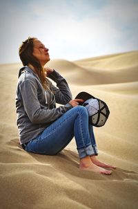 Side view of woman sitting on beach