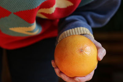 Midsection of woman holding oranges