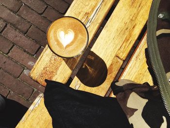 Directly above shot of coffee on wooden bench