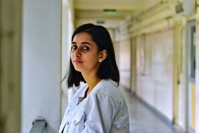 Portrait of woman standing in corridor