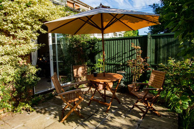 Empty chairs and table in yard