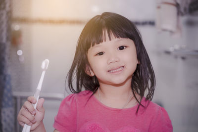 Portrait of smiling girl holding indoors