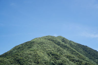 Low angle view of mountain against blue sky