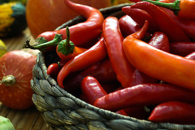 Close-up of red chili peppers in wicker container on table