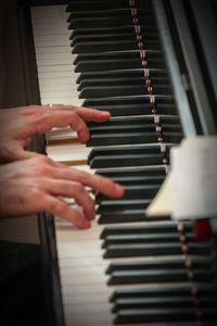 Cropped hands of person playing piano