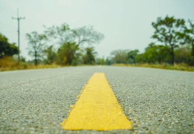 Surface level of yellow road against sky