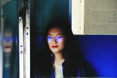 Young woman wearing eyeglasses while sitting in train