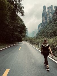 Full length of woman on road against sky